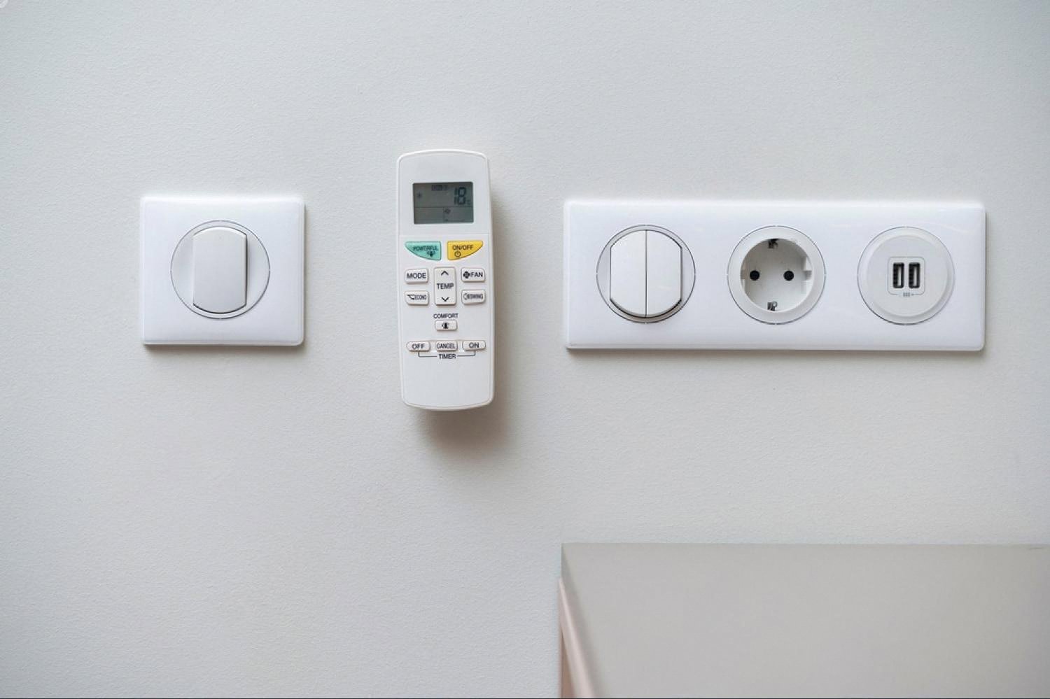Wall-mounted HVAC controller next to power sockets in a modern UAE property